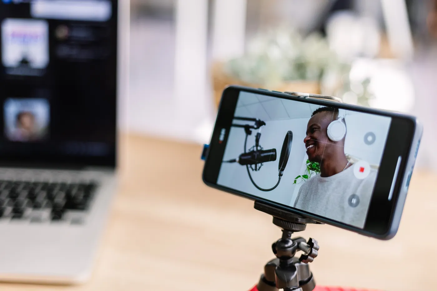 Un créateur enregistre son podcast, cadré par un téléphone sur trépied